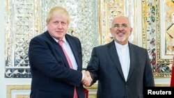 Iran's Foreign Minister Mohammad Javad Zarif shakes hands with Britain's Foreign Secretary Boris Johnson during their meeting in Tehran, Dec. 9, 2017.