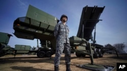 FILE - In this Jan. 18, 2018, file photo, a soldier stands next to a surface-to-air Patriot Advanced Capability-3 missile vehicle in Japan The U.S. missile system has recently been established in Iraq, April 10, 2020.
