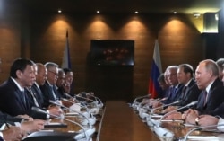 Russian President Vladimir Putin (R) and Philippine's President Rodrigo Duterte, both flanked by officials, are seen meeting in Sochi, Russia, Oct. 3, 2019.