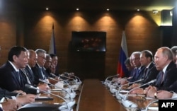 Russian President Vladimir Putin (R) and Philippine's President Rodrigo Duterte, both flanked by officials, are seen meeting in Sochi, Russia, Oct. 3, 2019.