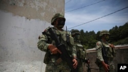 FILE - Mexican Army soldiers stand guard in Chiapas state, Mexico, Aug. 3, 2021. Four people died after Mexican army troops opened fire on a truck carrying migrants on Oct. 1, 2024, according to an official.