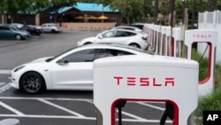 FILE - Tesla vehicles are charged at a charging station in Anaheim, Calif., Friday, June 9, 2023. Owners of General Motors and Ford electric vehicles will be able charge at many of Tesla's large network of stations across the U.S. starting next year. (AP Photo/Jae C. Hong)