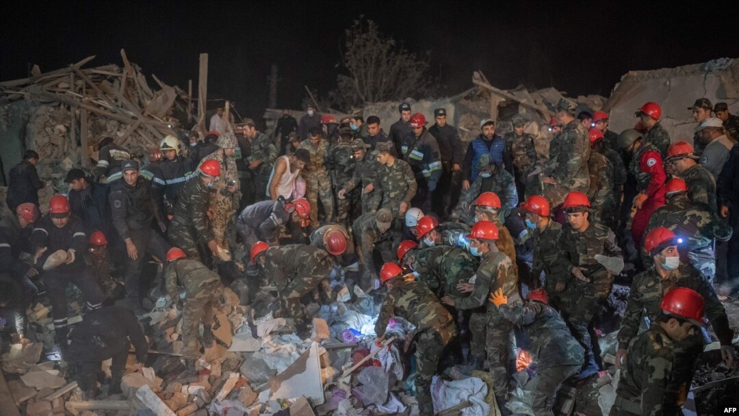 Equipas de resgate trabalham num local atingido por um rocket durante os combates na região separatista de Nagorno-Karabakh, na cidade de Ganja, Azerbaijão, no início de 17 de outubro de 2020 