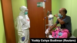 Dokter Cheras Sjarfi berbincang dengan seorang pasien di ruang isolasi di tengah lonjakan kasus baru COVID-19, di sebuah rumah sakit di Jakarta, 1 Juli 2021. (Foto: Yuddy Cahya/Reuters)