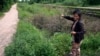 FILE - Sok Koeun, a villager who lives along the Funan Techo Canal, collects firewood for cooking at her home at Prek Takeo village, eastern Phnom Penh, Cambodia, July 30, 2024. 