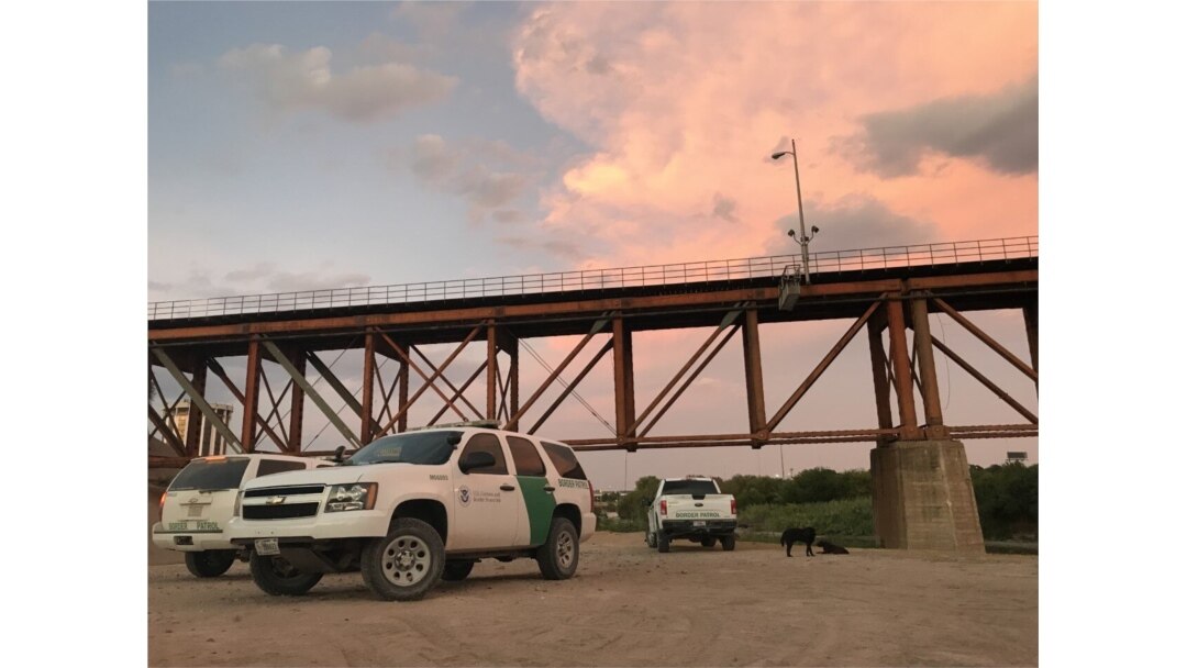U.S. Border Patrol agents await a detainee transfer under a train bridge in Laredo, Texas, on Aug. 6, 2019. (V. Macchi/VOA)