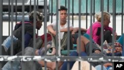 ARCHIVO - Un grupo de inmigrantes aguarda a ser procesado en la localidad de Marthon, en Florida, Estados Unidos, en febrero de 2023.