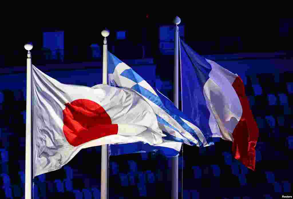 The Japanese, Greek and French flags are pictured during the closing ceremony REUTERS/Carlos Barria