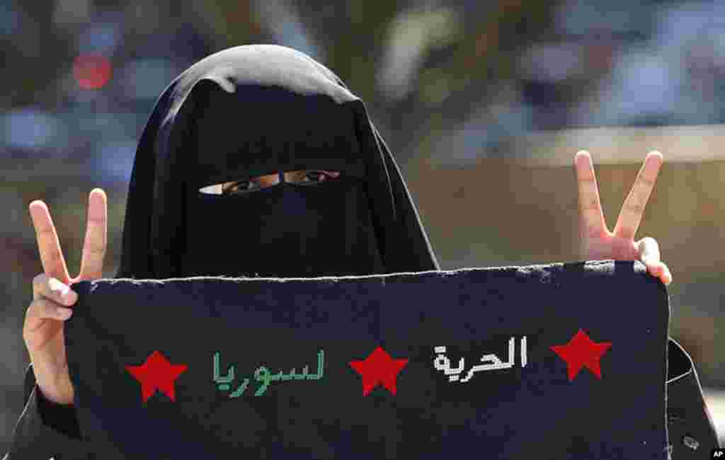 A Palestinian student in Gaza City holds a black flag reading "Freedom, Syria" during a demonstration against Syria's President Bashar Assad and his regime, February 21, 2012. (AP)