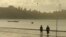 In this Oct. 5, 2016 photo, people walk on a beach in Kyaukpyu on the Bay of Bengal in the Rakhine region, Myanmar, where many residents rely on fishing and farming to survive. China’s big development plans for the town on Myanmar's west coast appear to hold few opportunities for local residents. Residents’ hope for factories that create jobs that may never be realized.