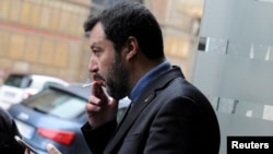FILE - Northern League's leader Matteo Salvini smokes a cigarette during an electoral rally in Palermo, Italy Feb. 14, 2018.
