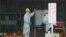 Guards read a whiteboard near the Fukushima-1 nuclear plant's main gate