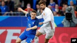 Gerard Piqué, à droite, et Kevin Gameiro lors d’un match de football international amical entre la France et l'Espagne au Stade de France à Paris, France, 28 mars 2017. 