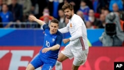 Gerard Pique d’Espagne, à droite, en duel avec Kevin Gameiro de France lors d’un match de football international amical entre la France et l'Espagne au Stade de France à Paris, France, 28 mars 2017. 