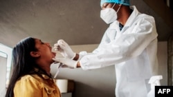 A nurse from Lancet Nectare hospital (R) performs a COVID-19 coronavirus test in Richmond, South Africa, Dec. 18, 2020. (Photo by LUCA SOLA / AFP)