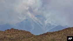 A portion of the Bush fire burns through the Tonto National Forest, June 16, 2020, as seen from Apache Junction, Ariz.