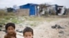 Two young Cambodian boys play near their slum home on the outskirts of Phnom Penh. 