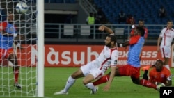 Les joueurs de la sélection nationale de la RDC en bleu et rouge défendent leur but contre une attaque de Yassine Chikhaoui de la Tunisie, à gauche, lors d’un match entre la RD Congo et la Tunisie en phase finale de la Coupe d’Afrique des Nations à Bata, en Guinée équatoriale, 26 janvier 2015.