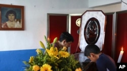 Twelve-year-old Jesus Ruiz stands before the coffin containing the remains of his father, Mexican journalist Jorge Celestino Ruiz Vazquez, in Actopan, Veracruz, Aug. 3, 2019. The state attorney's office said Ruiz Vazquez was found dead at his home Friday.