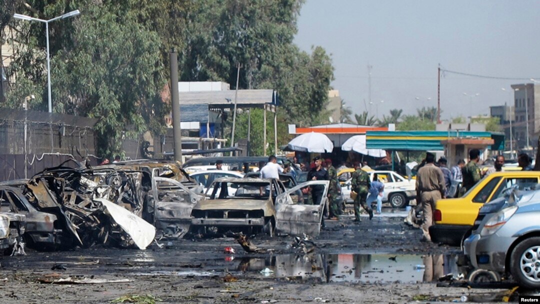 Petugas keamanan Irak memeriksa kendaraan yang hancur akibat serangan bom di Khazimiyah, Baghdad (15/8).