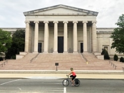 A woman is biking past the National Gallery of Art in a usually busy part for tourists in Washington DC. (Photo: Diaa Bekheet)