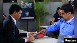 El presidente de Venezuela, Nicolás Maduro, compra su certificado de "ahorro en oro" en el Banco Central. Foto: Cortesía vía Reuters.