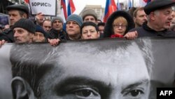FILE - Russia's opposition supporters carrying a banner bearing a portrait of slain Kremlin critic Boris Nemtsov during a march in central Moscow, March 1, 2015. 