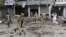 Afghan security force members inspect the site of a suicide attack in Jalalabad, April 18, 2015. 