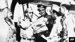 FILE - An Associated Press war correspondent reads a copy of Stars and Stripes aboard the exchange liner Gripsholm, as it arrived at Algiers, in this image provided by the U.S. Signal Corps, May 23, 1944.