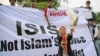 FILE - A Muslim woman releases a dove as a symbol of peace during a rally against the Islamic State group in Jakarta, Indonesia, Sept. 5, 2014.