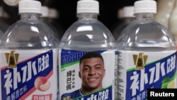 北京一家商店的货架上摆放着的印有法国足球运动员姆巴佩头像的东鹏饮料集团有限公司生产的瓶装饮料。(2027年10月27日)
