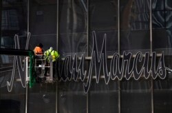 FILE - Workers install a sign for the Neiman Marcus department store at the Hudson Yards development in New York, March 8, 2019.
