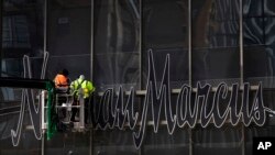 Workers install a sign for the Neiman Marcus department store at the Hudson Yards development in New York, March 8, 2019.
