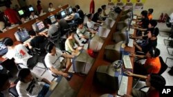 Remaja China menggunakan komputer di internet cafe di Beijing (foto; ilustrasi). 