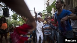 Yensy Villarreal, 9, (C), who lives in Miami, dances in the backyard of his home with friends in celebration for becoming a Santero after passing a year-long rite of passage in the Afro-Cuban religion Santeria, Havana, July 5, 2015.
