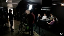 The director of NC Noticias, Manuel Bolivar, left, attends the broadcast of a debate show, at the studio of the new online news network launched by ex-combatants of the Revolutionary Armed Forces of Colombia, FARC, in Bogota, Colombia, Nov. 14, 2107.