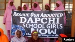 Des écolières attendant l'arrivée du président nigérian Muhammadu Buhari au collège scientifique et technique des filles à Dapchi, au Nigeria, le 14 mars 2018.