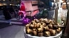 Chestnuts are displayed at a food vendor as a person dressed as Santa Claus offers rides, Dec. 12, 2024, in New York. 