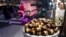 Chestnuts are displayed at a food vendor as a person dressed as Santa Claus offers rides, Dec. 12, 2024, in New York. 