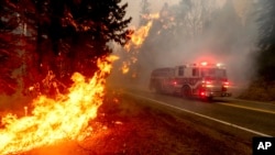 រថយន្ដ​ពន្លត់​អគ្គីភ័យ​មួយ​គ្រឿង​បើក​កាត់​ផ្លូវ​ Highway 168 ដើម្បី​​ពន្លត់​ភ្លើង​ឆេះព្រៃ Creek Fire នៅ​ក្នុង​សង្កាត់ Fresno រដ្ឋ California សហរដ្ឋអាមេរិក ថ្ងៃទី៧ ខែកញ្ញា ឆ្នាំ២០២០។ 