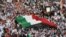 Islamist, nationalist and liberal opposition groups carry a large national flag as they gather to protest the Kuwait government's amendment of the electoral law and support a boycott on the country's election on November 30, 2012 in Kuwait City. 