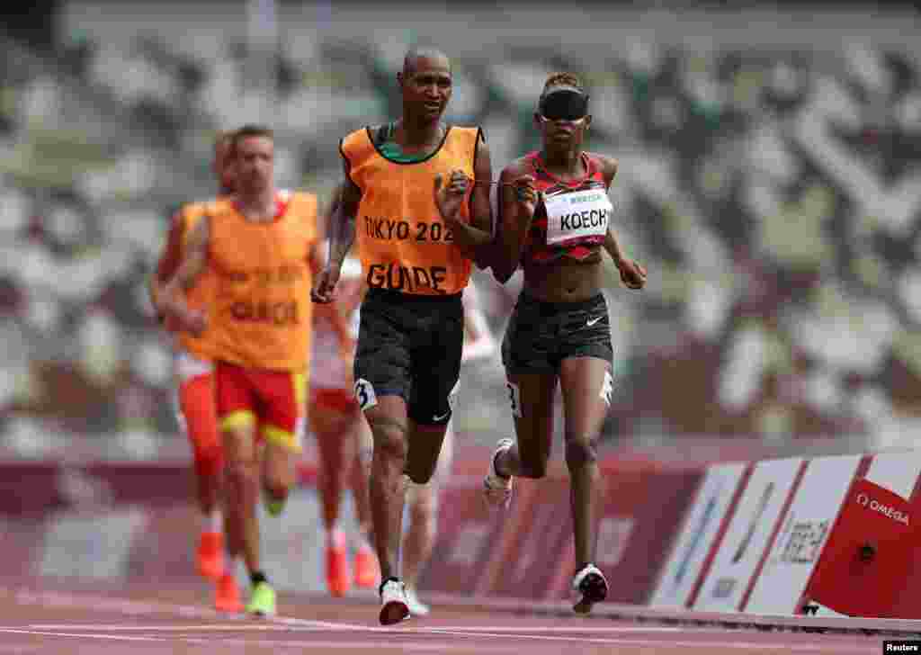 Nancy Chelangat Koech of Kenya and guide Geoffrey Kiplangat Rotich in action REUTERS/Molly Darlington.&nbsp;