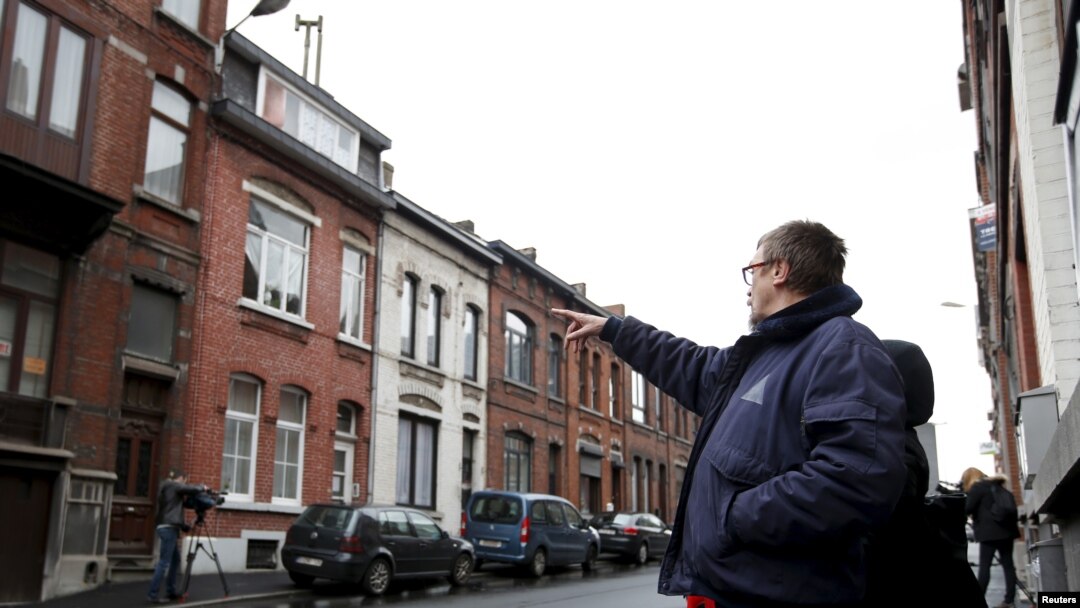 A resident points at a house located in a street called "Rue du Fort" in Charleroi, Belgium, Jan. 13, 2016. 