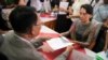 FILE - Myanmar opposition leader Aung San Suu Kyi, right, submits her documents for the upcoming general poll, election commission office, Yangon, Myanmar, July 29, 2015.