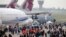 Visitors walk by a Boeing 777-300ER of China Airlines at left, and and Airbus A400M, at right, during the Paris Air Show, at Le Bourget airport, east of Paris, June 15, 2015.