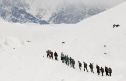 Sekelompok tentara Pakistan membawa senjata mereka menuju pos mereka di K2, pegunungan Karakoram, Pakistan, 8 September 2014. (Foto: dok).