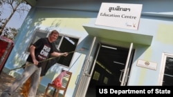 Deputy Chief of Mission Paul Mayer adds a coat of paint to the new Wildlife Education Center 