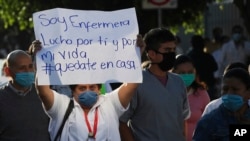 A woman carries a sign that reads in Spanish "I'm a nurse. I fight for you and for my life. Stay home." during a protest in Mexico City, April 13, 2020.