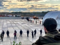 A protester looks out at police and armed security officers guarding the construction site. If built, the landfill will be among the largest in Europe. (Photo: C. Maynes)