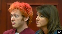 James Holmes de 25 años apareció por primera vez en una corte tres días después de la matanza junto a su abogado.